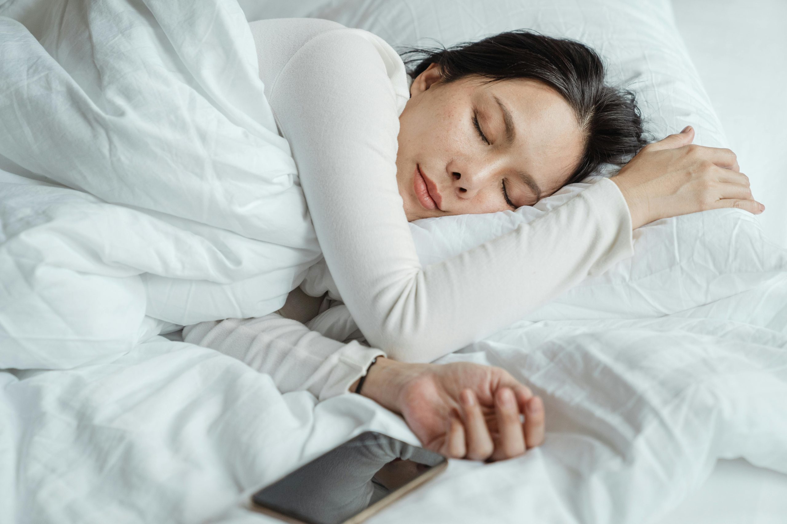 A woman soundly sleeping in her bed.