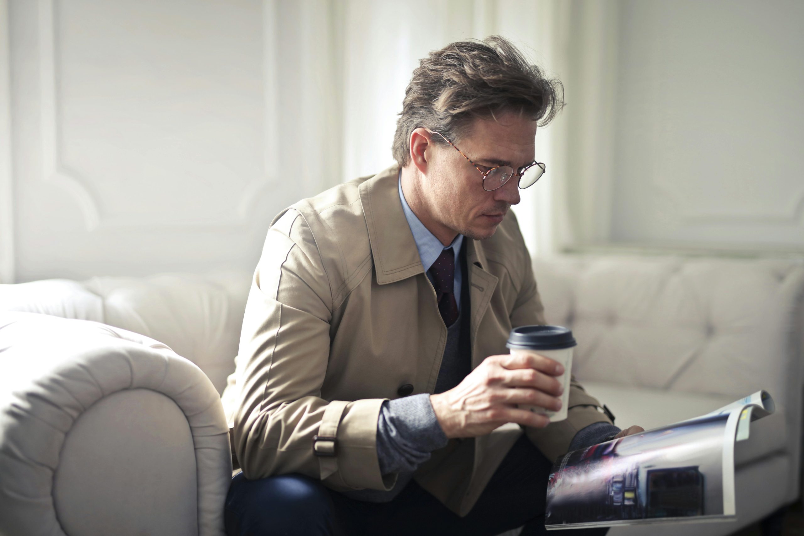 A man taking a break at work with a drink and some reading material.